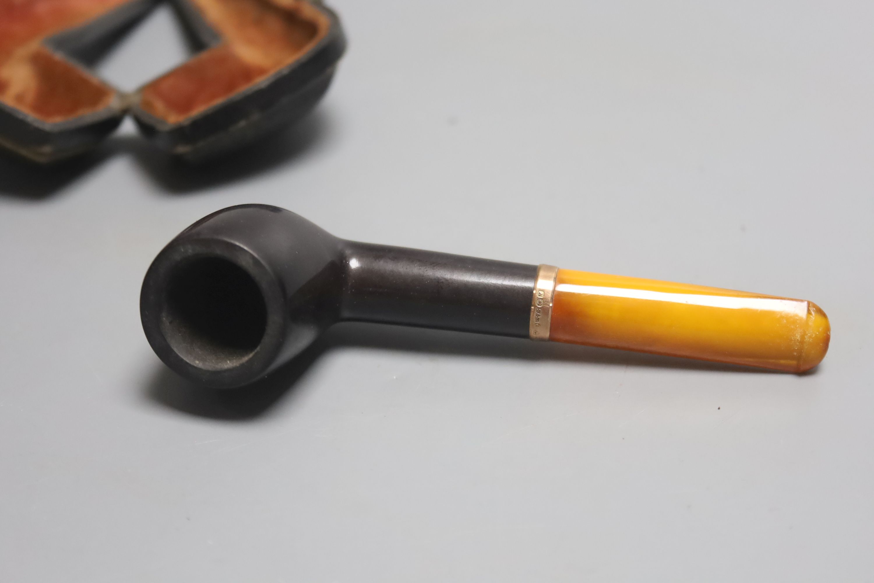 A cased pipe with amber mouthpiece and 9ct gold collar.